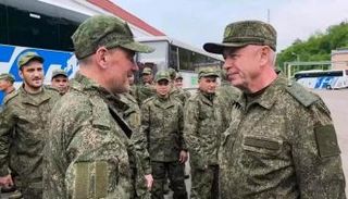 نائب وزير الدفاع الروسي (يمين) يتحدث مع جنود عائدين من أوكرانيا
