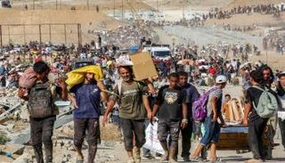 فلسطينيون يحملون أكياسًا من المساعدات وسط قطاع غزة