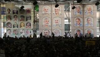 لافتة تعرض صور القادة والعلماء الذين قُتلوا في الغارات الإسرائيلية