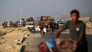 فلسطينيون فارّون جنوبًا، على الطريق الساحلي قرب مخيم النصيرات للاجئين بوسط غزة