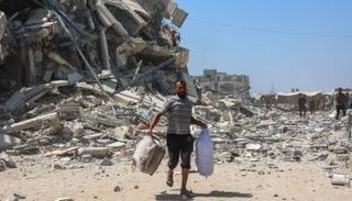 فلسطيني يجمع بعض مقتنياته بعد قصف منزله في غزة