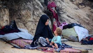 فلسطينية وابنها خلال عمليات النزوح