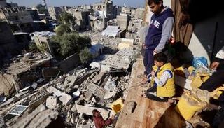 فلسطينيون وسط الركام في غزة