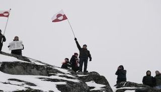 أشخاص يلوحون بأعلام غرينلاند خلال تظاهرة احتجاجا على خطط ترامب