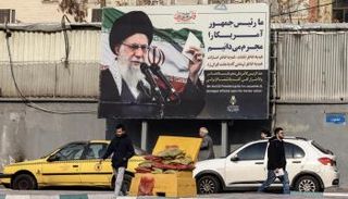 إيرانيون يمرون أمام لوحة إعلانية تظهر خامنئي في طهران