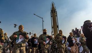عسكريون إيرانيون يرفعون صورة خامنئي