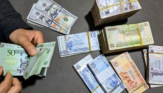 عملات ورقية من الدينار الليبي والدولار الأمريكي- أرشيفية
