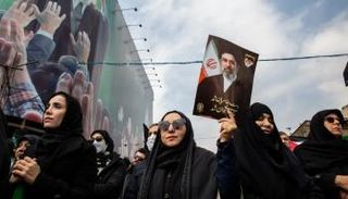 إيرانية ترفع صورة المرشد الجديد