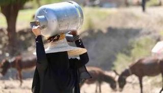 سيدة يمنية تحمل قنينة غاز منزلي على رأسها