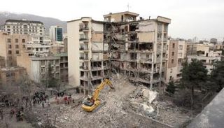 حفارة تزيل الأنقاض من المباني السكنية المدمرة في شمال طهران