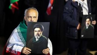 رجل يحمل صورة المرشد الإيراني مجتبى خامنئي في طهران