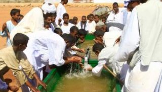 سودانيون يشربون من مياه استُخرجت من بئر جوفية في ولاية القضارف شرق السودان 