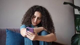 فتاة تتابع وسائل التواصل عبر هاتفها