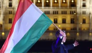 رئيس الوزراء الجديد حاملا علم البلاد