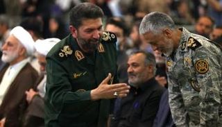 قائد في الحرس الثوري يصافح ضابط بالجيش الإيراني خلال تجمع بمسجد الخميني