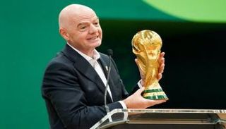 رئيس الاتحاد الدولي لكرة القدم (فيفا) جياني إنفانتينو يحمل كأس العالم