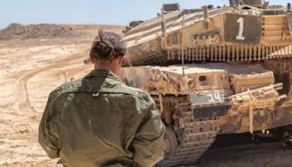 جندية إسرائيلية تقف أمام مدرعة