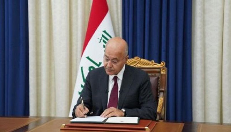 الرئيس العراقي خلال التوقيع على مرسوم إجراء الانتخابات