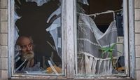 أوكراني ينظر من نافذة مبنى تعرض لهجوم بكييف