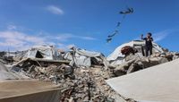 صبي فلسطيني يُحلّق بطائرة ورقية قرب خيام نُصبت على أنقاض مبنى في غزة